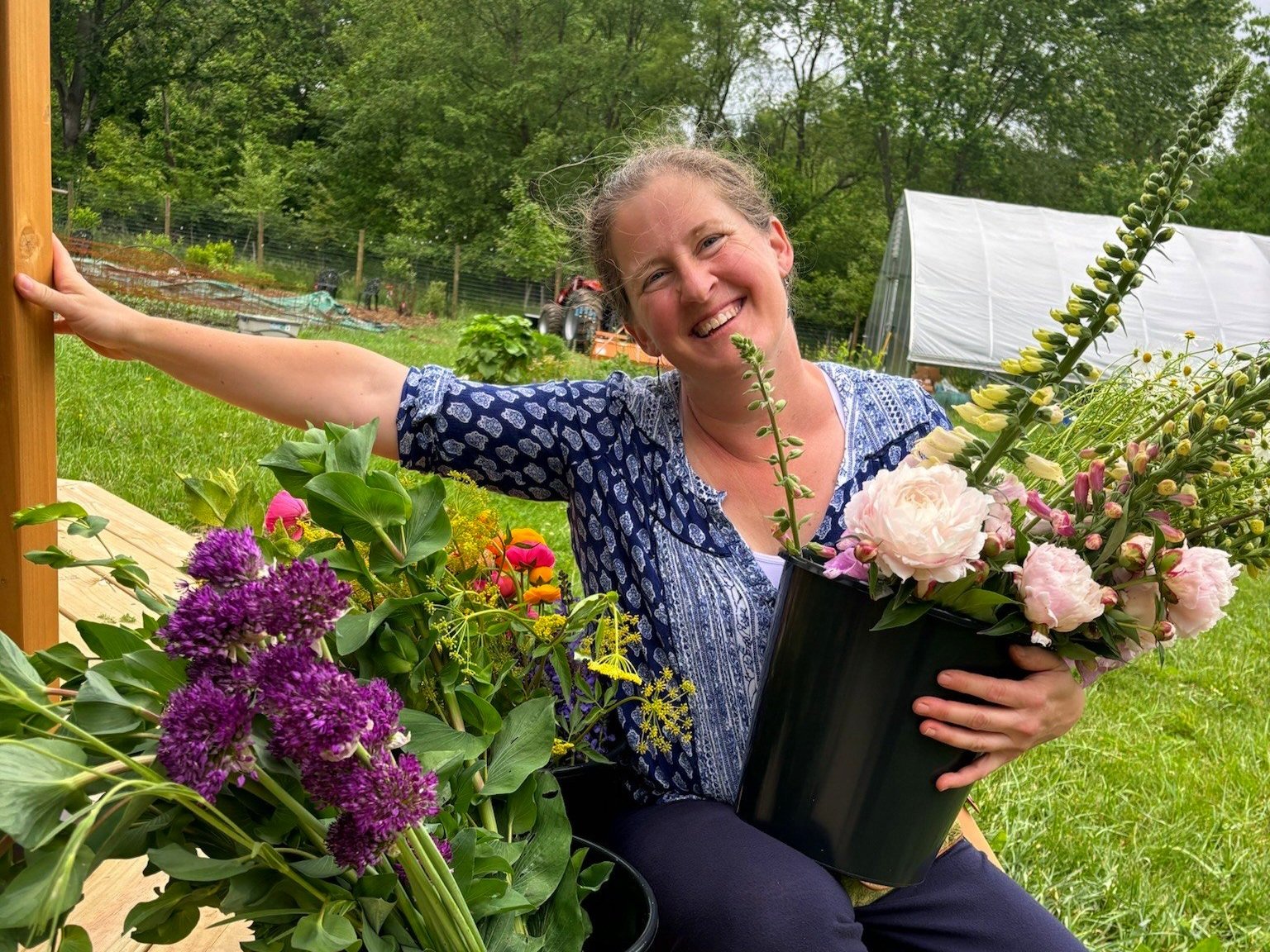 Joanna holding a bucket of fresh-cut flowers at Nuthatch Gardens